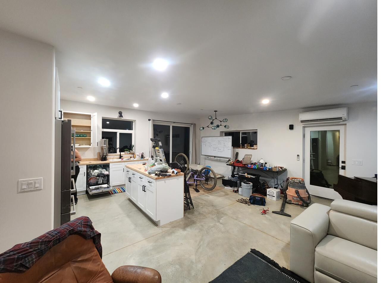 Interior of finished home: polished concrete floors and white kitchen