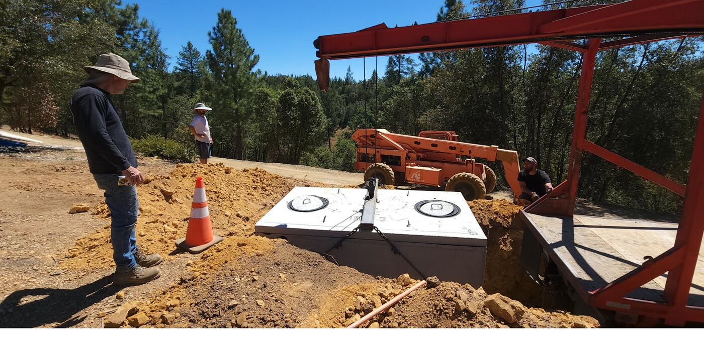 Concrete septic tank being set at a rural California property