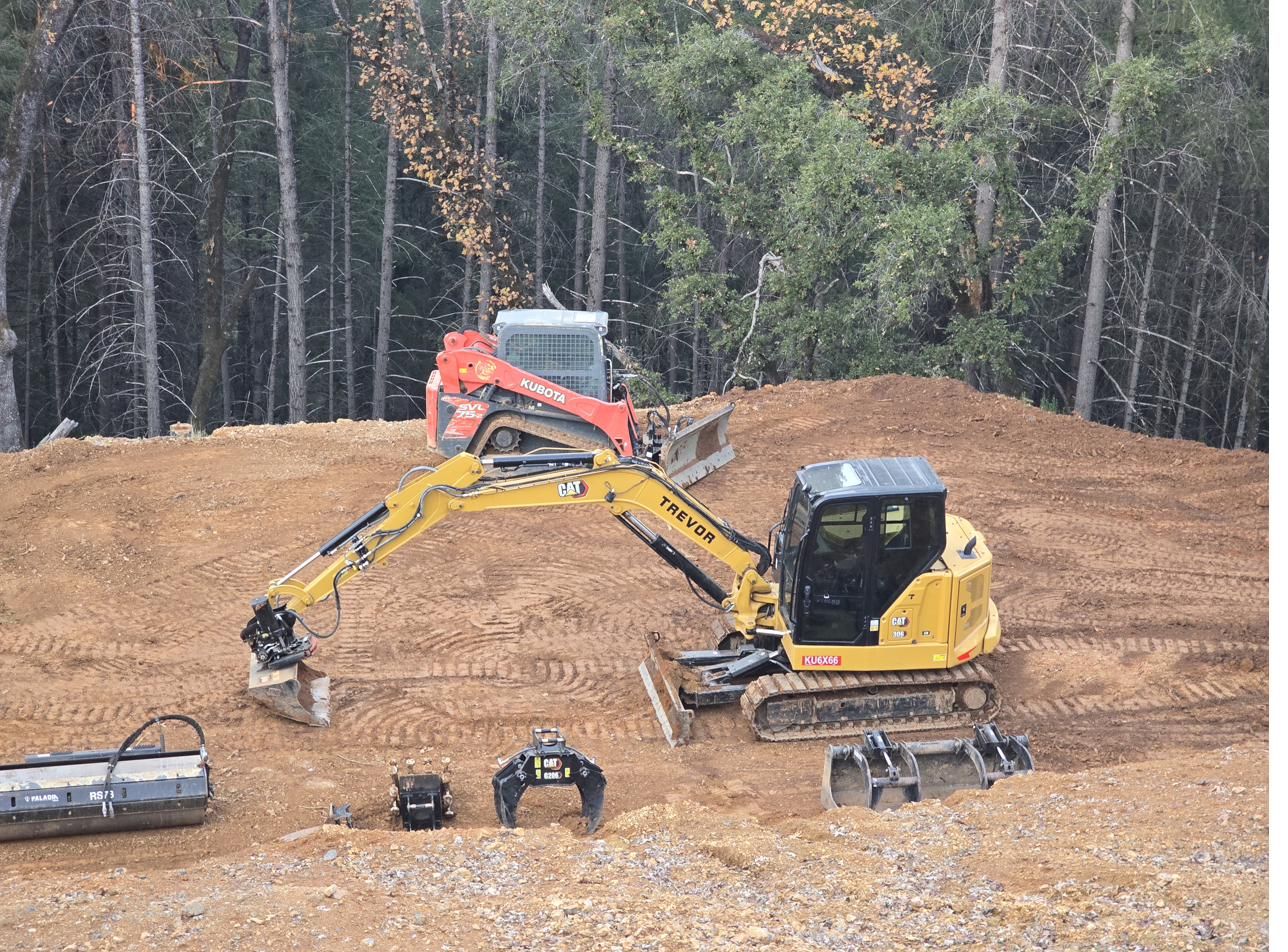 CAT 306 excavator with tiltrotator and Kubota SVL 75-2 skid steer working a graded pad